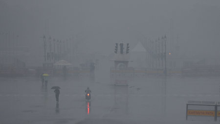 NEW DELHI, INDIA - DECEMBER 27: Commuters out in Cold and Rain Afternoon at Kartavya Path near India Gate, on December 27, 2024 in New Delhi, India. Delhi and nearby areas received moderate to heavy rain on Friday, leading to a drop in temperatures. The Iのeditorial素材