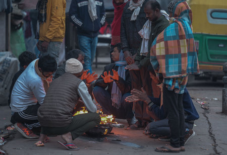 NEW DELHI, INDIA - DECEMBER 30: People are gathered around bonfires to protect themselves on a cold winter morning, at NH24 Near Narwana Road on December 30, 2024 in New Delhi, India. North India is reeling under cold weather with temperatures plummeting のeditorial素材