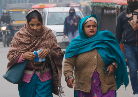 GURUGRAM, INDIA - DECEMBER 29: People walks through a street on a cold winter morning at MDI Chowk on December 29, 2024 in Gurugram, India. North India is reeling under cold weather with temperatures plummeting across several states. As per IMD, the minimのeditorial素材