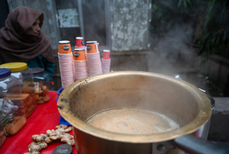 NOIDA, INDIA - DECEMBER 30: A tea vendor making tea on the roadside in a cold morning. Cold has increased in Delhi-NCR, mercury has gone down further, morning temperature was 8のeditorial素材