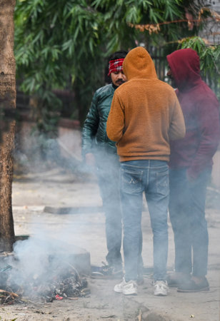NOIDA, INDIA - DECEMBER 30: People stood around bonfire near Sector 24 road to escape the cold. Cold has increased in Delhi-NCR, mercury has gone down further, morning temperature was 8のeditorial素材