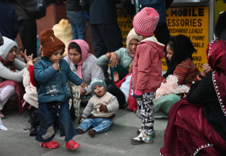 NEW DELHI, INDIA - JANUARY 4: Passengers sit on a platform covering themselves with woolen cloths at New Delhi Railway Station, several train services are impacted due to dense fog, on January 4, 2025 in New Delhi, India. A dense blanket of fog once againのeditorial素材