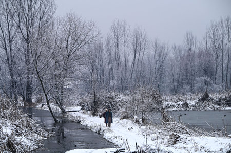 SRINAGAR INDIA JANUARY 6 2025  People walk on snow covered wooden foot bridge in the interior of Dal Lake after a snowfall on January 6, 2025 in Srinagar, India. (Photo By Waseem Andrabi Hindustan Times)のeditorial素材