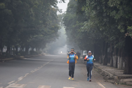 GURUGRAM, INDIA - JANUARY 12: People take a morning walk in a sector-29 road amid cold weather near Huda Ground, Rajiv Chowk, on January 12, 2025 in Gurugram, India. North India is reeling under cold weather with temperatures plummeting across several staのeditorial素材