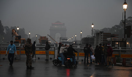 NEW DELHI, INDIA - JANUARY 11: People stuck during drizzling rainfall near India Gate, on January...