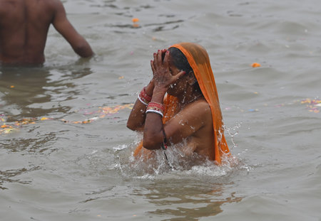 PRAYAGRAJ INDIA JANUARY 13 2025 Devotees take a holy dip at Sangam the confluence of the Ganges Yamuna and Saraswati rivers during the Maha Kumbh Mela on January 13 2025 in Prayagraj India The 45 day Mahakumbh Mela 2025 celebrated as the largest gatheringのeditorial素材