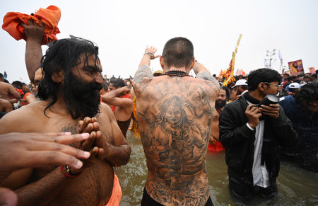 PRAYAGRAJ INDIA JANUARY 14 2025 A seers greet to the foreign devotee who has tattoos of Lord Shiva...