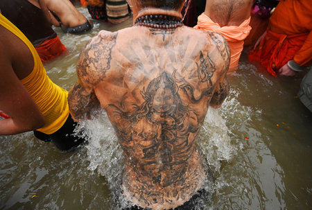 PRAYAGRAJ INDIA JANUARY 14 2025 Foreign devotees having tattoos of Lord Shiva and other Hindu Gods on his body take holy dip at Sangam on the occasion of Makar Sankranti the confluence of the Ganges Yamuna and Saraswati rivers during the Maha Kumbh Mela oのeditorial素材