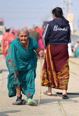 PRAYAGRAJ, INDIA - JANUARY 28: An old devotee walks at the Mela ground to reach Triveni Sangam to...