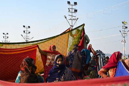 PRAYAGRAJ, INDIA - JANUARY 28: Women dries their clothes as Hindu Devotees arrive to take a holy dip at sangam on the Maha Kumbh Mela, on January 28, 2025 in Prayagraj, India. (Photo by Salman Ali/Hindustan Times )のeditorial素材