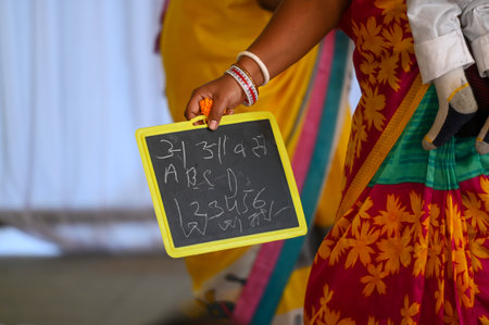 NOIDA, INDIA - FEBRUARY 3: A child during \"Hate Khori\"- a ceremony where little children are introduced to the first alphabet on Saraswati Puja, on February 3, 2025 in Noida, India. Basant Panchami, also known as Saraswati Puja, marks the beginning of sのeditorial素材