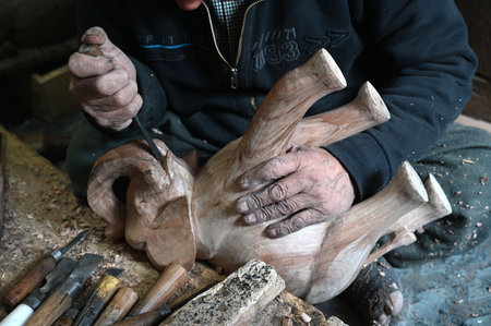 SRINAGAR INDIA FEBRUARY 24 2025 Walnut wood carving deaf mute artisan Mohammed Yousaf Muran works on a handcrafted walnut wood piece at his workshop in downtown area on February 24 2025 in Srinagar India Kashmir is home to the world s finest walnut wood aのeditorial素材