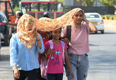 NOIDA, INDIA - MARCH 26: As temperatures rise in Delhi-NCR, commuters cover their heads to escape the heat in Sector 38 A, on March 26, 2025 in Noida, India. Delhi recorded this season's hottest day on Tuesday (March 25), with the maximum temperature soarのeditorial素材