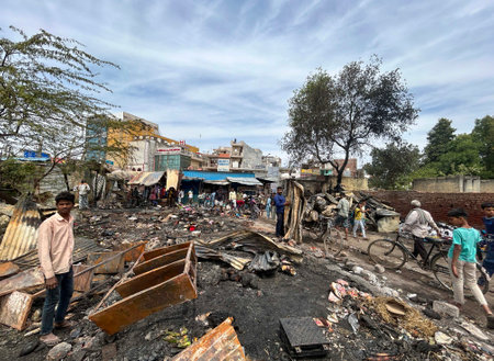 GURUGRAM, INDIA - MARCH 29: People salvage charred belongings from a site where a massive fire erupted at a slum area market in Basai Enclave sector-9B near Basai chowk, on March 29, 2025 in Gurugram, India. No one was injured in this incident. Six fire tのeditorial素材