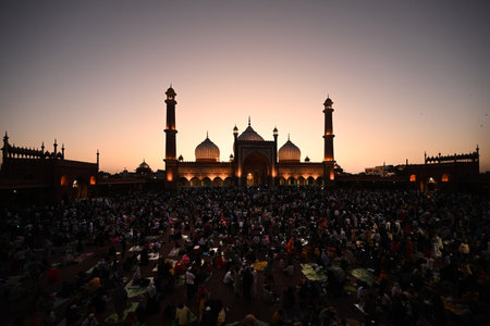 NEW DELHI, INDIA - MARCH 30: Muslims people break their fast on the last day of Ramadan Roza iftar in front of Illuminated Jama Masjid on the eve of Eid-ul-Fitr festival, on March 30, 2025 in New Delhi, India. (Photo by Sonu Mehta/Hindustan Times )のeditorial素材