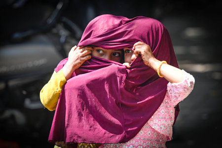 NEW DELHI, INDIA - APRIL 2: Children seen covering their head during a Hot Day at Nizamuddin on April 2, 2025 in New Delhi, India. (Photo by Sanchit Khanna/Hindustan Times )のeditorial素材