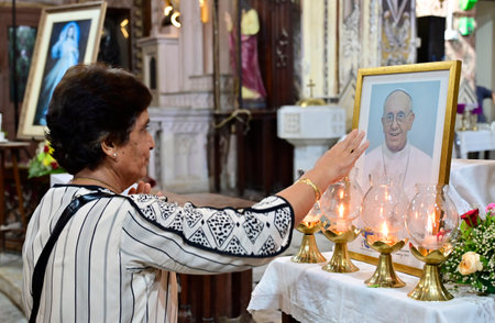 MUMBAI INDIA APRIL 21 2025  Followers of Christian religion pays respects in front of a portrait of the late Pope Francis during a condolence meeting, at Cathedral of the Holy Name Church on April 21, 2025 in Mumbai, India. Pope Francis, the leader of theのeditorial素材