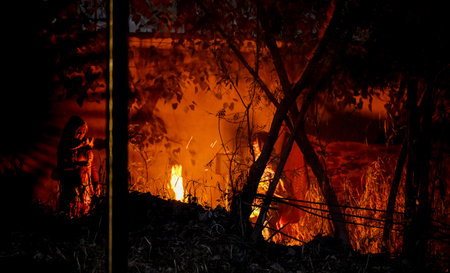 NEW DELHI, INDIA - JANUARY 5: Homeless People huddled around a bonfire during morning hours amid cold weather at Sarai Keley Khan on January 6, 2024 in New Delhi, India. Foggy morning challenges Delhi-NCR with intensifying cold wave, mercury dips further のeditorial素材