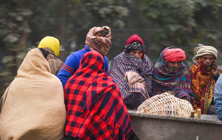 GURUGRAM, INDIA - JANUARY 4: Construction workers wrapped in a blanket are going to their work on a tractor on a cold foggy morning at National Highway-48 near Signature Tower Chowk on January 4, 2024 in Gurugram, India. According to IMD, Delhi NCR is likのeditorial素材