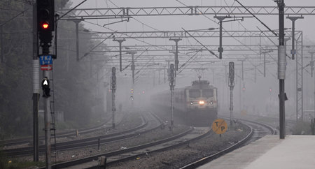 NEW DELHI, INDIA - JANUARY 5: A Train move slowly amid low visibility due to fog on a cold winter morning, at Tilak Brij Railway Station on January 6, 2024 in New Delhi, India. Foggy morning challenges Delhi-NCR with intensifying cold wave, mercury dips fのeditorial素材