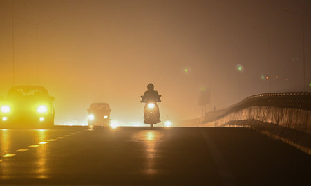 NEW DELHI, INDIA - JANUARY 5: Commuters are seen wearing warm clothes amid cold and foggy morning at NH24 Near Akshardham temple on January 6, 2024 in New Delhi, India. Foggy morning challenges Delhi-NCR with intensifying cold wave, mercury dips further aのeditorial素材