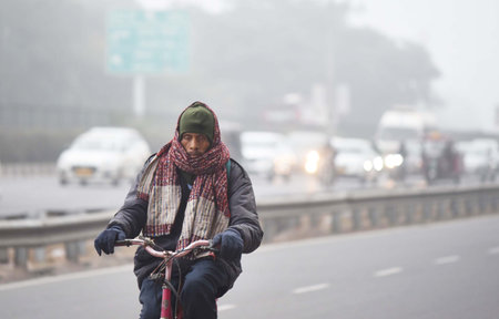 GURUGRAM, INDIA â JANUARY 5: People seen wearing warm clothes while going to office on a cold winter morning at NH-48 near Star Mall, on January 5, 2024 in Gurugram, India. Foggy morning challenges Delhi-NCR with intensifying cold wave, mercury dips furのeditorial素材