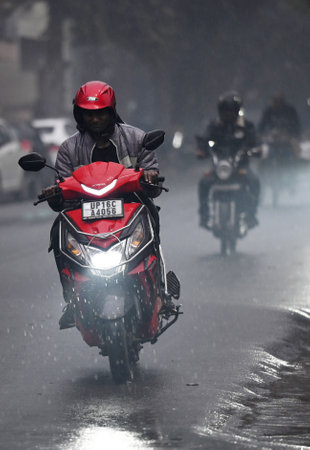 NOIDA, INDIA - JANUARY 31: Commuters during light rain in winter, on January 31, 2024 in Noida, India. There was light rain in Delhi NCR on a cold day, which increased the severe cold in North India. There will be light rain in Delhi-NCR today. According のeditorial素材