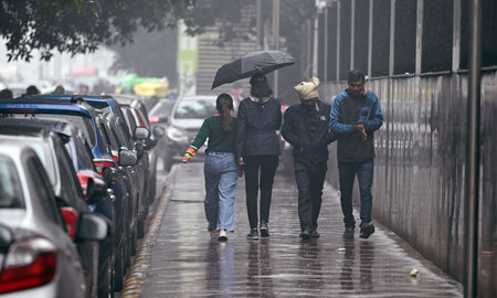 NEW DELHI, INDIA - JANUARY 31: Commuters protect themselves from sudden rain at Connaught Place, on January 31, 2024 in New Delhi, India. (Photo by Sanjeev Verma/Hindustan Times )のeditorial素材