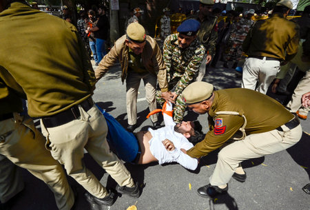 NEW DELHI, INDIA - MARCH 5:  Delhi Police and Paramilitary Security forces try to detaining Akhil Bharatiya Vidyarthi Parishad (ABVP) activists during the demonstration against Mamata Banerjee's government to demand justice for women who have fallen victiのeditorial素材