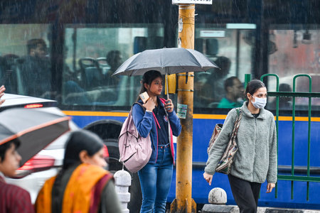 NEW DELHI, INDIA - MARCH 2: Commuters during light rain in winter, rain increased the severe cold, at Pandav Nagar Road on March 2, 2024 in New Delhi, India. Rain lashed parts of the national capital on Saturday, bringing down the pollution levels in the のeditorial素材