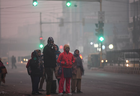 NEW DELHI, INDIA --- JANUARY 13: Commuters are seen wearing warm clothes at Narwana Road amid cold and foggy morning on January 13, 2024 in New Delhi, India. Foggy morning challenges Delhi-NCR with intensifying cold wave, mercury dips further across Northのeditorial素材