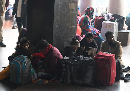 NEW DELHI, INDIA â€“ JANUARY 13: Passengers sit on a platform at New Delhi Railway Station,...