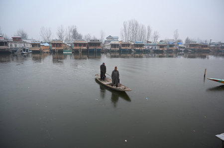 SRINAGAR, INDIA - JANUARY 4: A Boatman rows a boat on a partially frozen surface of Dal Lake on a cold morning  on January 4, 2024 in Srinagar, India. (Photo by  Waseem Andrabi/Hindustan Times)のeditorial素材