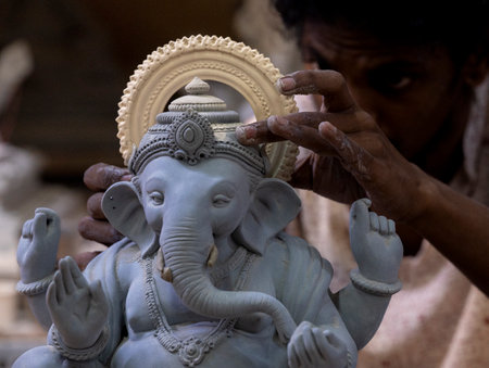 MUMBAI, INDIA - AUGUST 8: An artisan from Trimurti Studio works on an idol of the elephant-headed Hindu god Lord Ganesha at a workshop ahead of the Ganesh Chaturthi festival at Lower Parel on August 8, 2023 in Mumbai, India.  (Photo by Anshuman Poyrekar/Hのeditorial素材