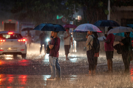 MUMBAI, INDIA - JULY 24:  People going through the heavy rain at Parel  on June 24, 2023 in Mumbai, India. The weather bureau in its forecast has issued a yellow alert for Mumbai and Thane indicating heavy rains at isolated places.  (Photo by Satish Bate/のeditorial素材