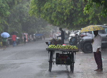 NOIDA, INDIA - JULY 9: Commuters seen out during heavy rains at Sector 12 road, on July 9, 2023 in Noida, India. Delhi-NCR was drenched with heavy rain on the intervening night of Friday, Saturday and Sunday. The overnight shower, which continued on Saturのeditorial素材