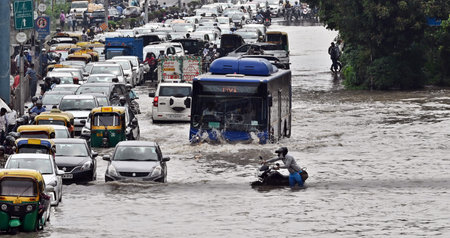 NEW DELHI, INDIA - JULY 14: Commuters make their way through the waterlogged ITO road due to the...