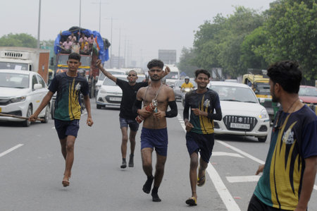GURUGRAM, INDIA - JULY 14: Dak Kanwariyas seen carrying holy water from the Ganga river in Haridwar to their hometown on the eve of the Shivaratri festival on NH-48 near sector-31 flyover on July 14, 2023 in Gurugram, India. (Photo by Parveen Kumar/Hindusのeditorial素材