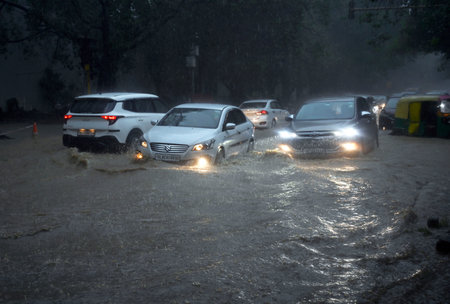 NEW DELHI, INDIA - JULY 9: Commuters move through a water logged stretch amid heavy rains at Sarojini Nagar, on July 9, 2023 in New Delhi, India. Delhi-NCR was drenched with heavy rain on the intervening night of Friday, Saturday and Sunday. The overnightのeditorial素材