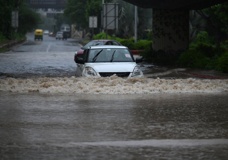 NOIDA, INDIA - JULY 26: Commuters pass through a heavily waterlogged stretch of road, at Sector 44, on July 26, 2023 in Noida, India. The residents of Delhi-NCR witnessed heavy rainfall. Commuters faced problems due to waterlogging in several areas. The Iのeditorial素材