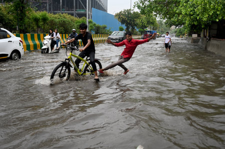 NOIDA, INDIA - JULY 8: Commuters pass through a heavily water logged stretch of road, at Sector 62, in Noida, India, on Saturday ,08, 2023. (Photo by Sunil Ghosh / Hindustan Times)のeditorial素材