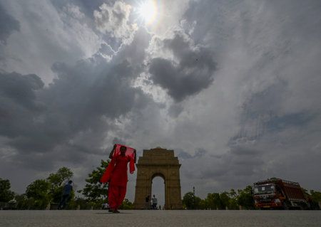 NEW DELHI INDIA JUNE 17 2023 People out in summer day on a cloudy afternoon near India Gate Lawn on...