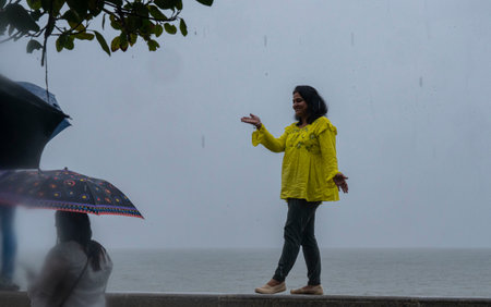 MUMBAI INDIA JUNE 25 2023 Pedestrians enjoy the rain at Marine Drive on June 25 2023 in Mumbai India Photo by Anshuman Poyrekar Hindustan Timesのeditorial素材