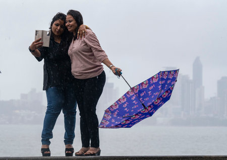 MUMBAI INDIA JUNE 25 2023 Pedestrians enjoy the rain at Marine Drive on June 25 2023 in Mumbai India Photo by Anshuman Poyrekar Hindustan Timesのeditorial素材