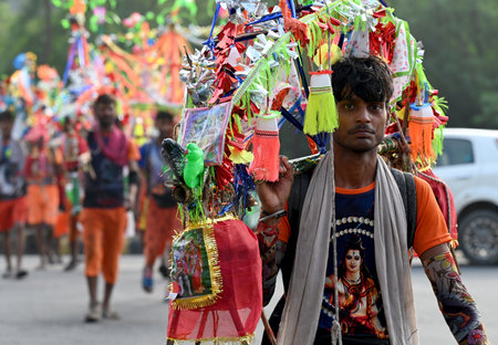 NOIDA INDIA JULY 10 2023 Kanwariya carries holy water collected from Ganga River in Haridwar during Kanwar Yatra at Sector 14A on July 10 2023 in Noida India Kanwariyas devotees of Hindu God Shiva who carry holy water kanwarof the river Ganga from Neelkanのeditorial素材