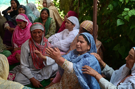 SRINAGAR, INDIA â AUGUST 5: Mother (C) of an Army soldier Waseem Ahmad Bhat, who was killed in an encounter mourns at her residence in Bandipora, north of Srinagar, on August 5, 2023 in Srinagar, India. Bhat was among three Army soldiers killed in an enのeditorial素材