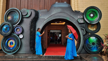 MUMBAI, INDIA â AUGUST 19: Womens are seen shooting photos behind the camera while a replica camera is being made outside during a photography exhibition organized in Thane on the occasion of 19 August world photography day, in Thane, on August 19, 2023のeditorial素材