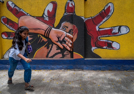 MUMBAI INDIA JUNE 11 2023 A girl walking past a graffiti wall at Kandivali a wall depicting cases of abuse of girls on June 11 2023 in Mumbai India Photo by Satish Bate Hindustan Timesのeditorial素材