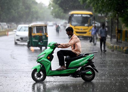 NOIDA INDIA JUNE 16 2023 Commuters out in the rain on the Sector 26 road on June 16 2023 in Noida India The India Meteorological Department had predicted light rain with gusty winds in Delhi NCR on Thursday According to the weather department this weatherのeditorial素材