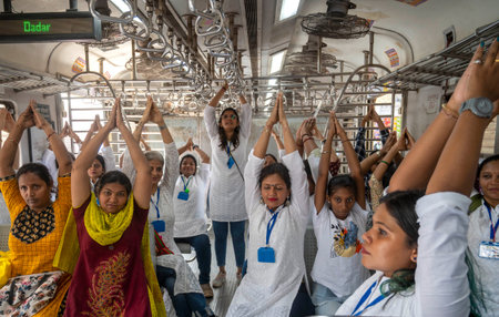 MUMBAI INDIA JUNE 21 2023 Commuters take part in a yoga session inside a local train to mark the...